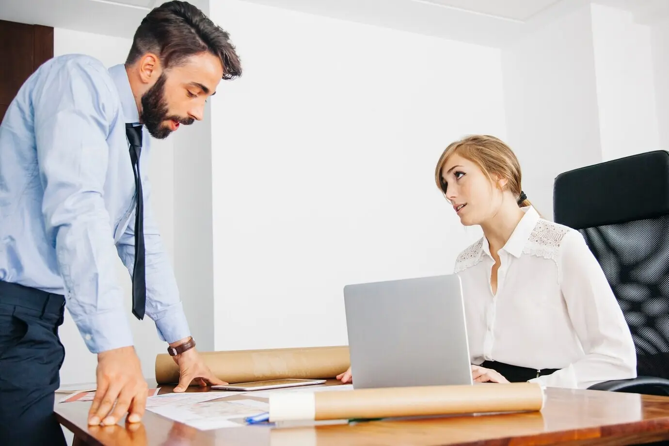 Архитекторы беседуют за рабочим столом.